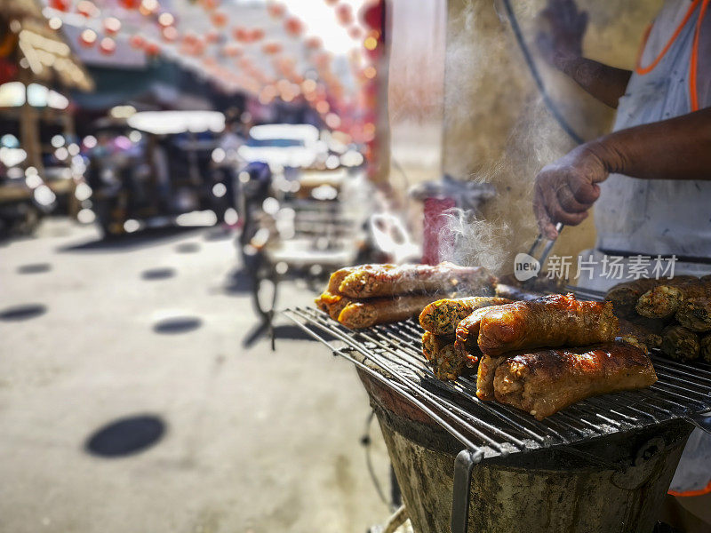 传统的泰国北部香肠(Sai Or)，在清迈市中心的泰国街头摊位上新鲜烹制，当人们走过街道在中国新年。